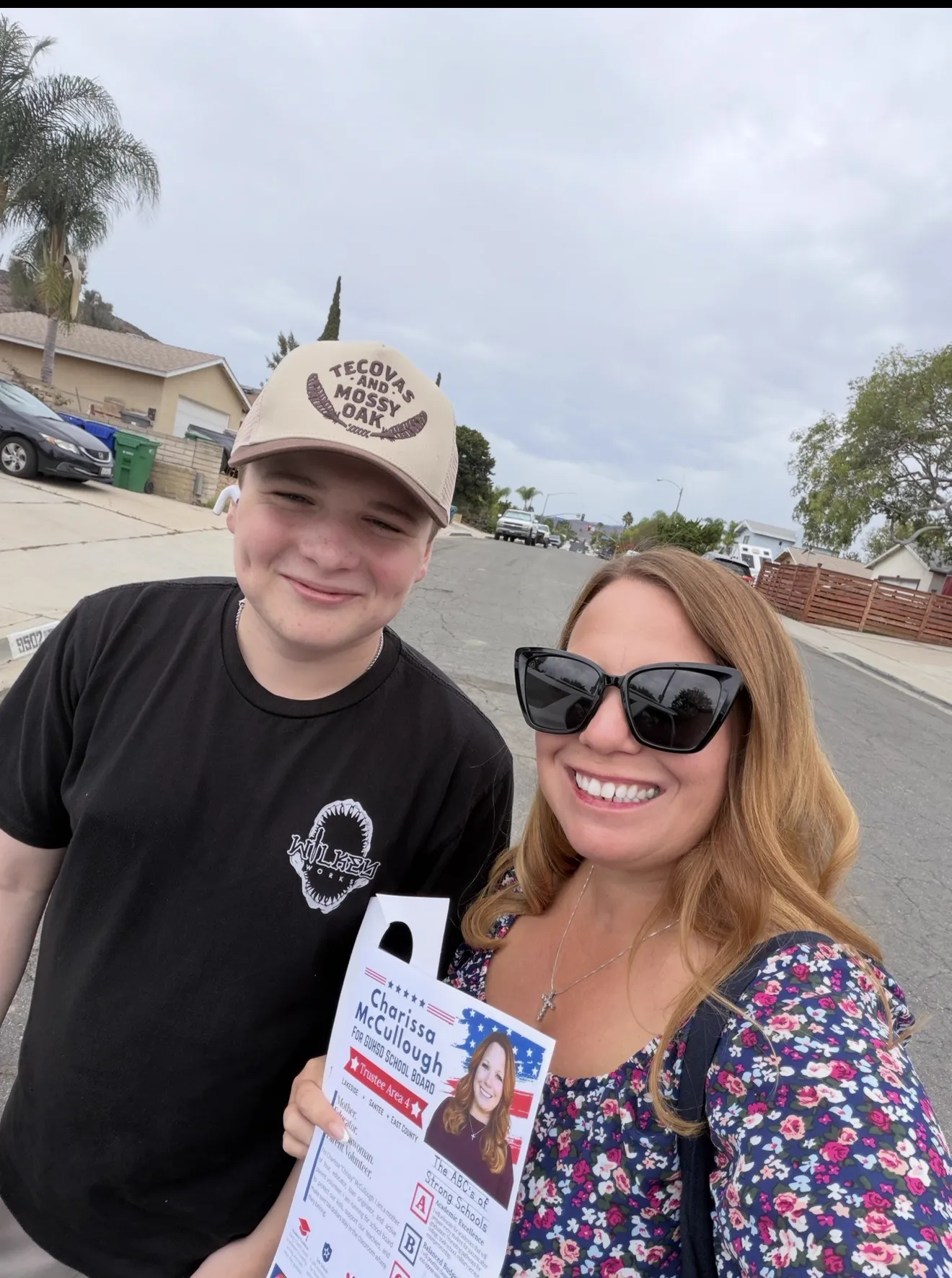 Charissa taking a canvassing selfie with a campaign flyer