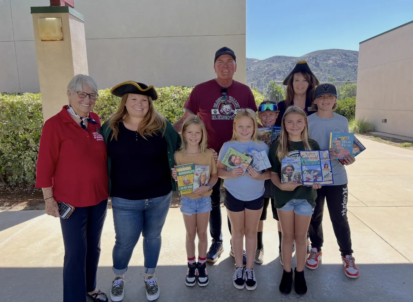 Charissa at a school event with students holding history books