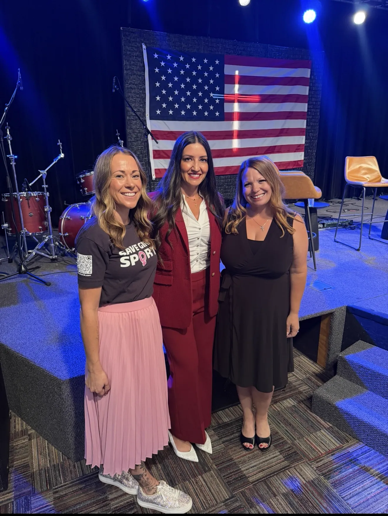Charissa with friends in front of an American flag